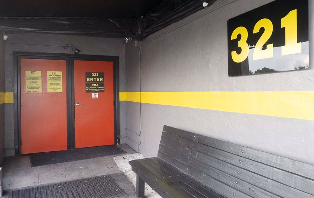 Red entrance doors, yellow striping and a large 321 sign at 321 Slammer.