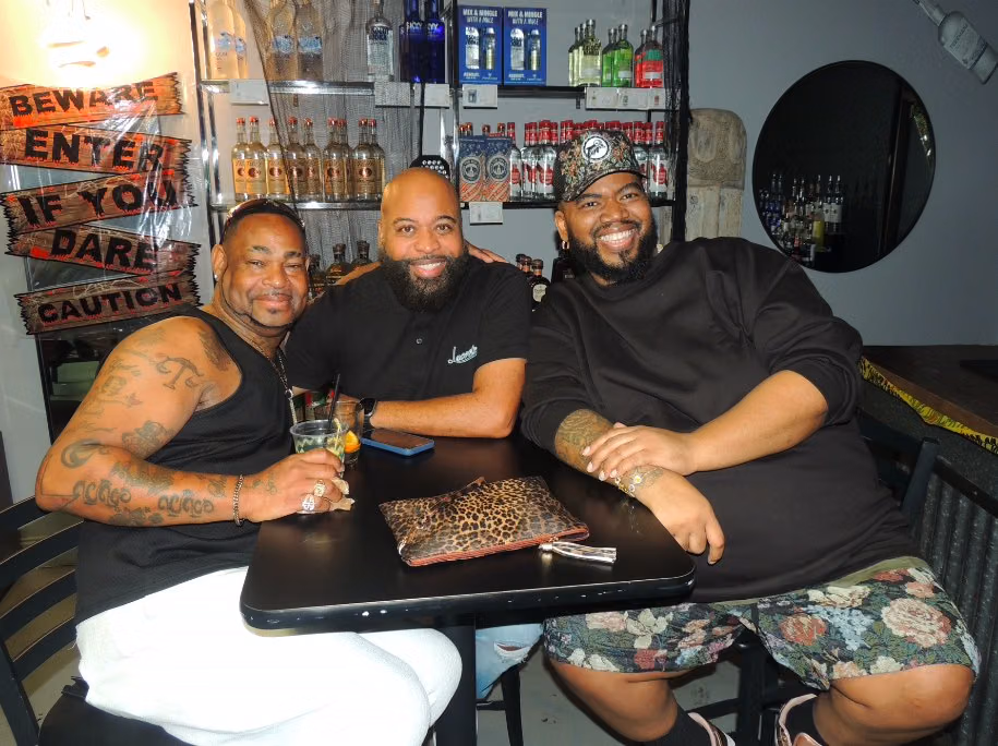 Three guests seated together at a table inside Chocolate City Bar & Grill.