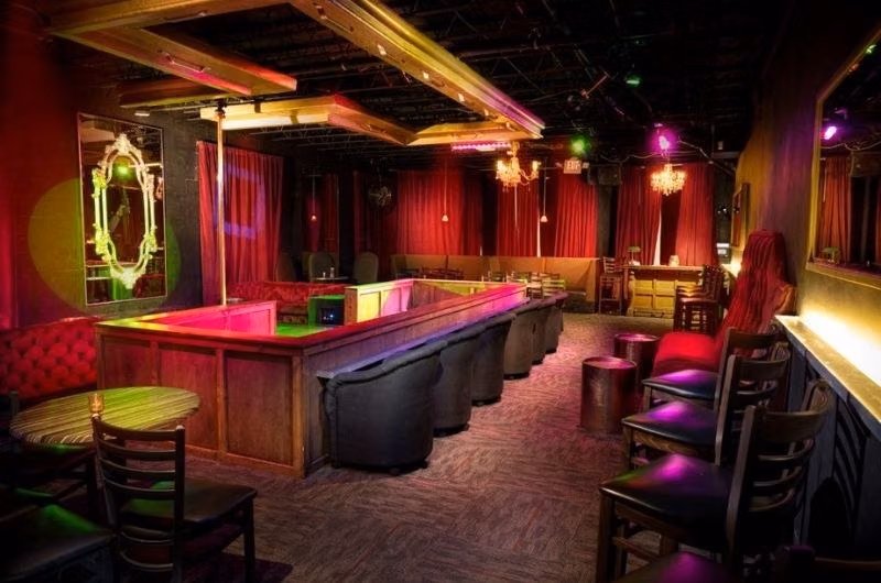 Red curtains, a stage and bar seating inside Johnsons Fort Lauderdale.