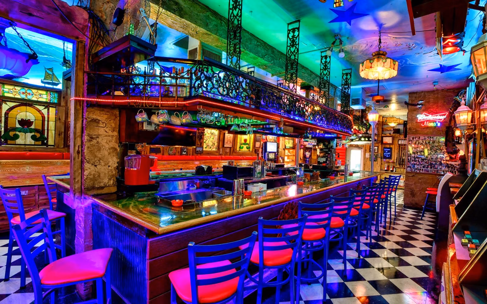 Colorful lights, stools and a long bar inside Mona’s in Fort Lauderdale.