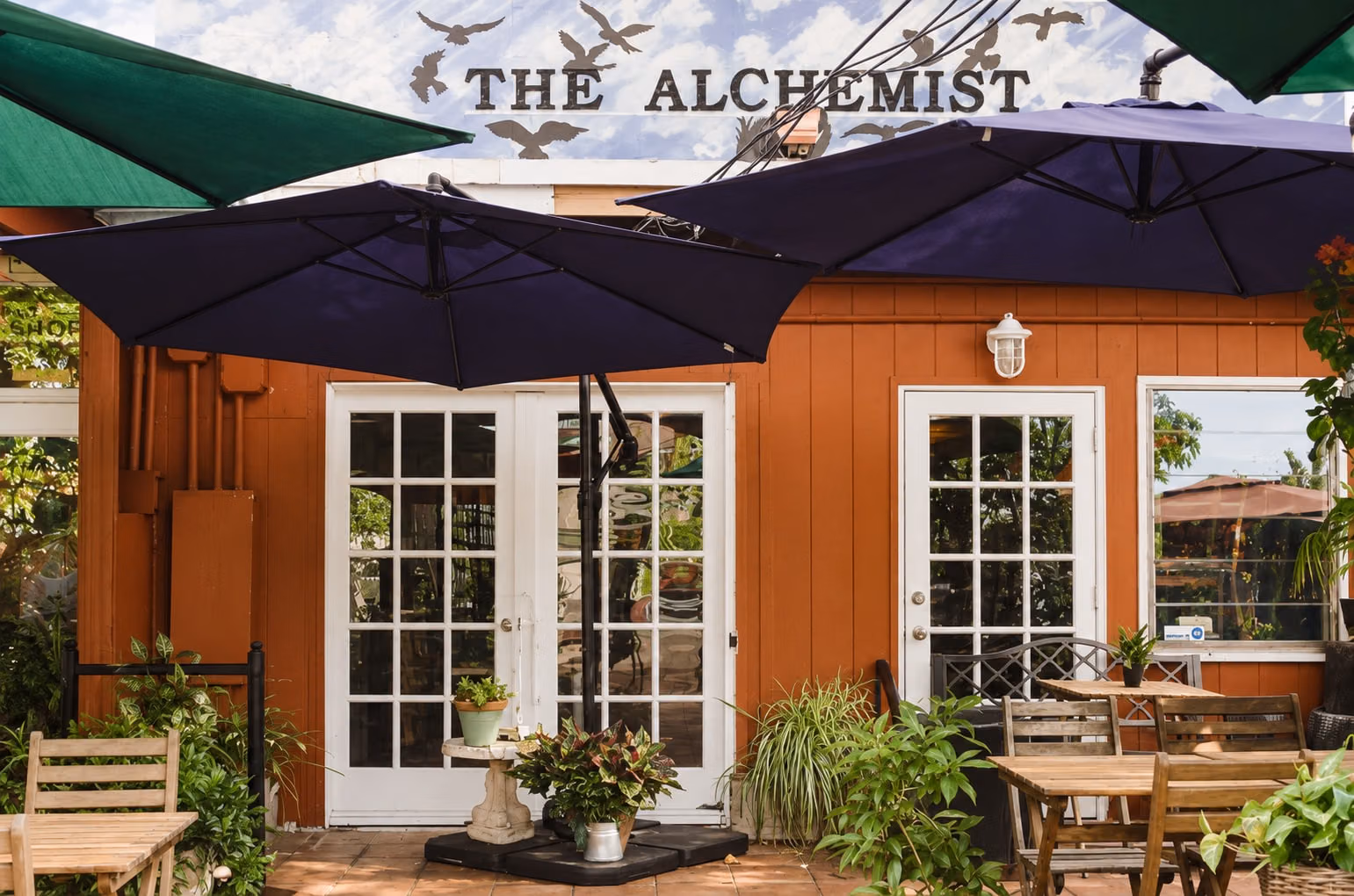 AI recreation of the entrance and outdoor tables at The Alchemist Café.