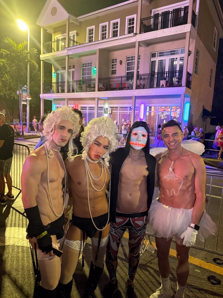 A group in white wigs, pearls, and Halloween costumes outside Johnson’s on Wilton Drive.
